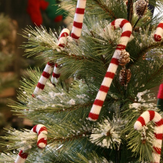 Knitted candy canes on a snow covered Christmas tree