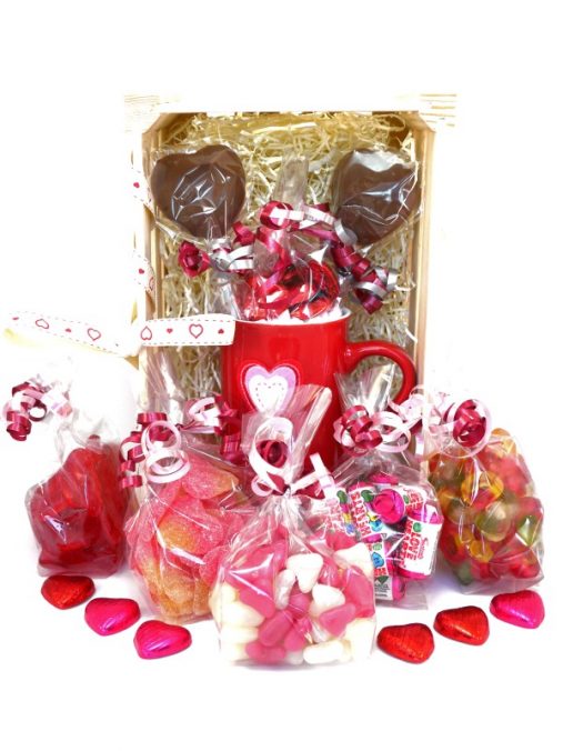 an image of one of our sweet Valentines hampers, containing a mug, hot chocolates, and jelly and fizzy sweets with a heart theme