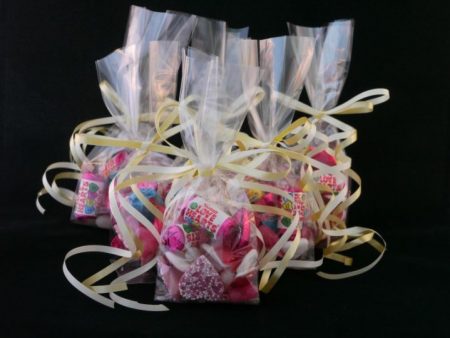 Corporate Gifts 4 A group photo of several wedding favour bags tied with gold ribbons and filled with love heart sweets, jelly heart sweet and chocolate heart sweets