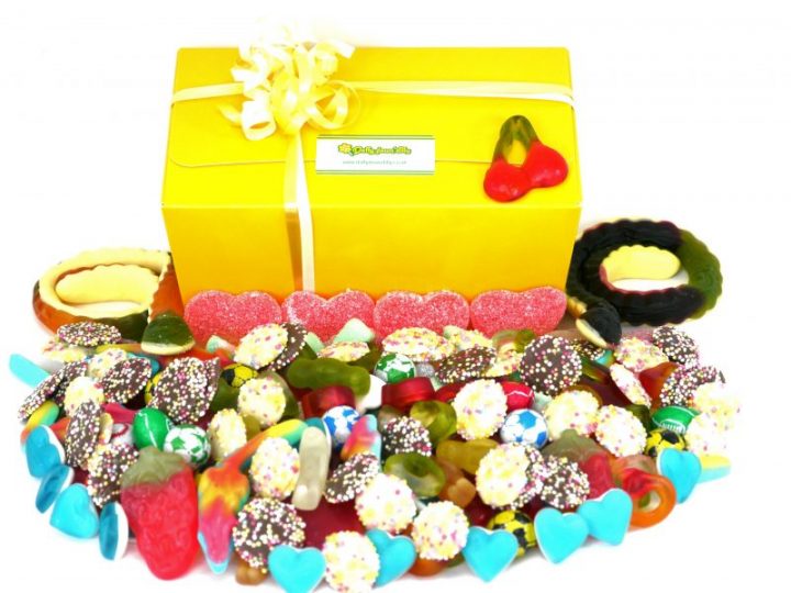 Pick and Mix sweet box. In front of our yellow presentation sweet box, a image of 1 kilo of assorted sweets. the perfect gift for anyone with a sweet tooth, chocolates, jelly sweets and fizzy sweets all nestle together in this stunning, colourful and delicious display.